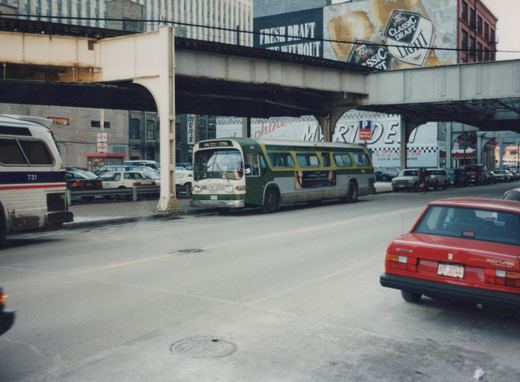 A green and white CTA bus, number 7861, is shown from the front, with another CTA bus, number 731, partially visible to the left. A red Volvo 740 Turbo is in the foreground. The scene is under a large, rusty elevated train structure on a snowy street.