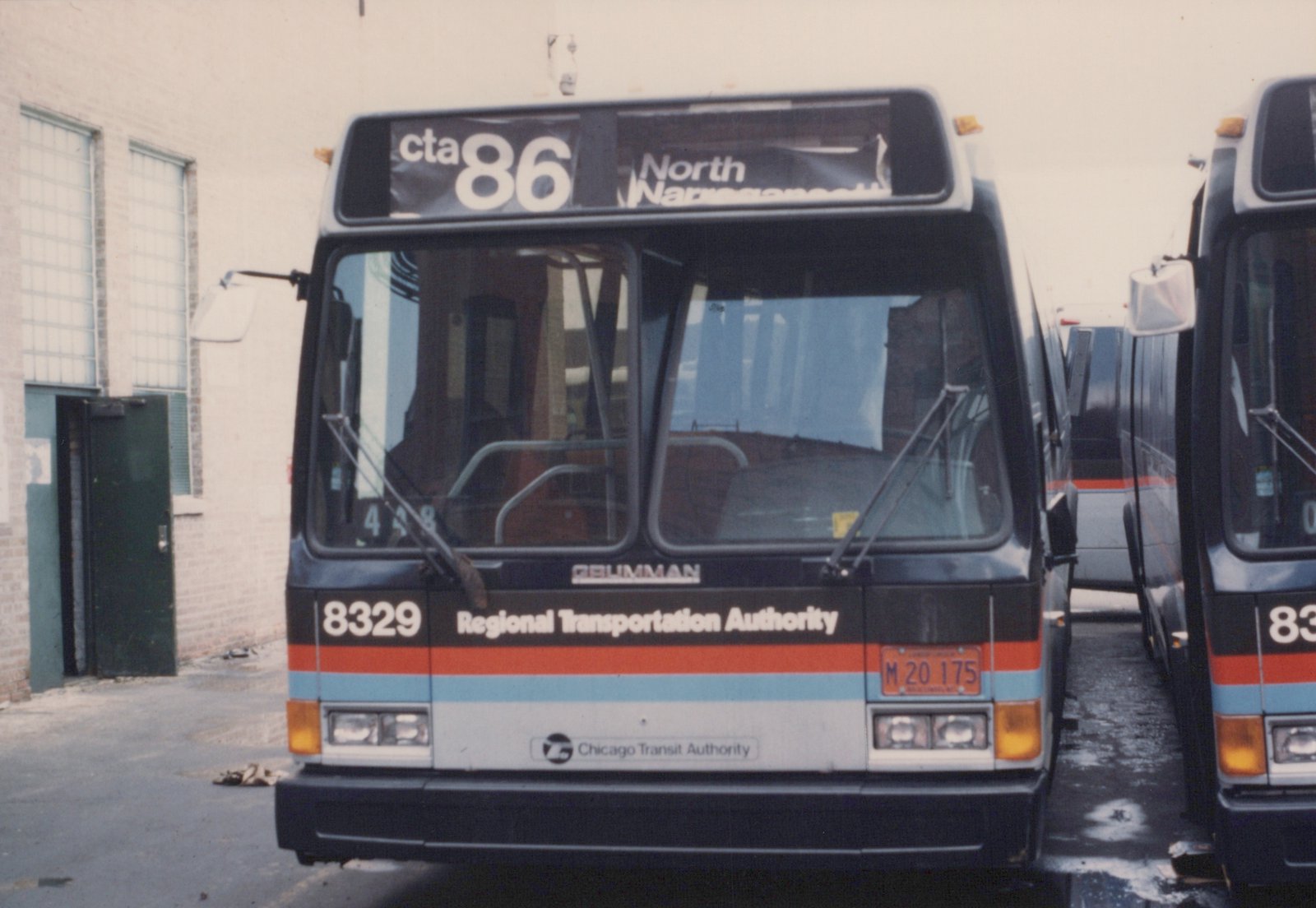 Front view of a dark-colored CTA bus with RTA livery, route 86 to North Narragansett, numbered 8329, parked in a garage with another bus visible to the right.