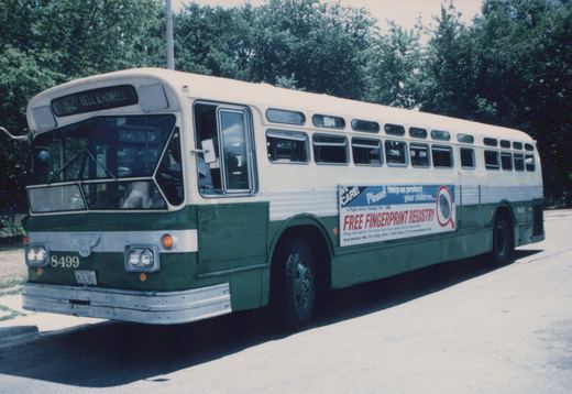 A green and cream Chicago Transit Authority bus from the 1970s is parked on a street, showing its front and side with a destination sign reading '82 Bell & Howell' and a 'Free Fingerprint Registry' advertisement.