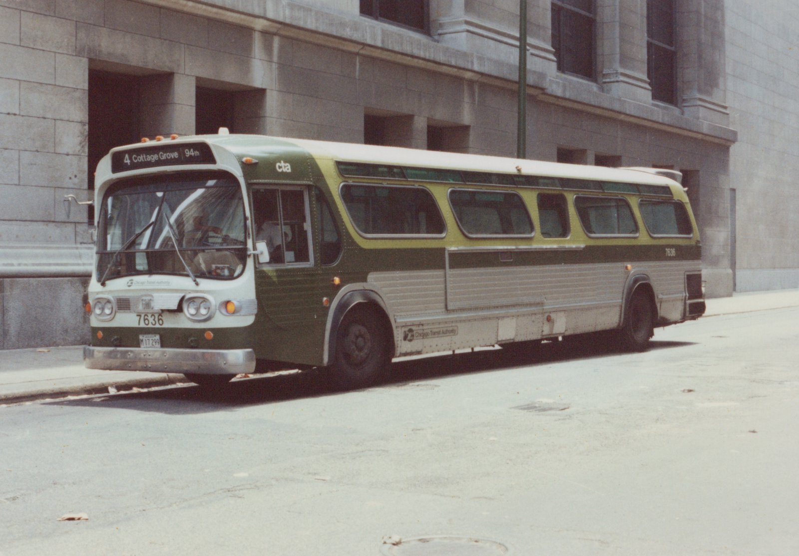 A green, cream, and silver Chicago Transit Authority bus, number 7636, is parked on a street next to a stone building, showing its front destination sign for route 4 Cottage Grove.