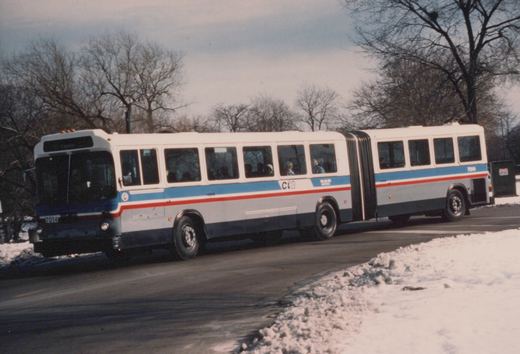 A white, blue, and red articulated bus with the number 7014 on a snow-lined street, operated by the Chicago Transit Authority.