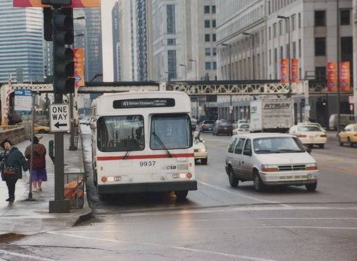 A white and red CTA bus with the number 9937 and destination sign reading 41 Elston/Clybourn is stopped on a city street. A one-way sign is visible on the sidewalk, and other cars and minivans are on the road.