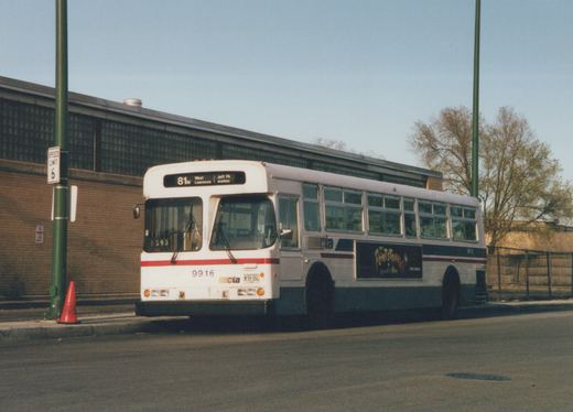 A white and blue Chicago Transit Authority bus numbered 9916 is parked on a city street, showing its route sign and a movie advertisement on its side.