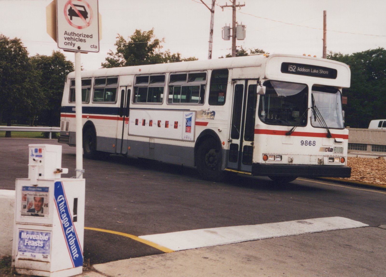 A white and blue Chicago Transit Authority bus, number 9868, is parked on the side of a street under an overcast sky, showing its front and side with route sign 152 to Addison Lake/Shore.