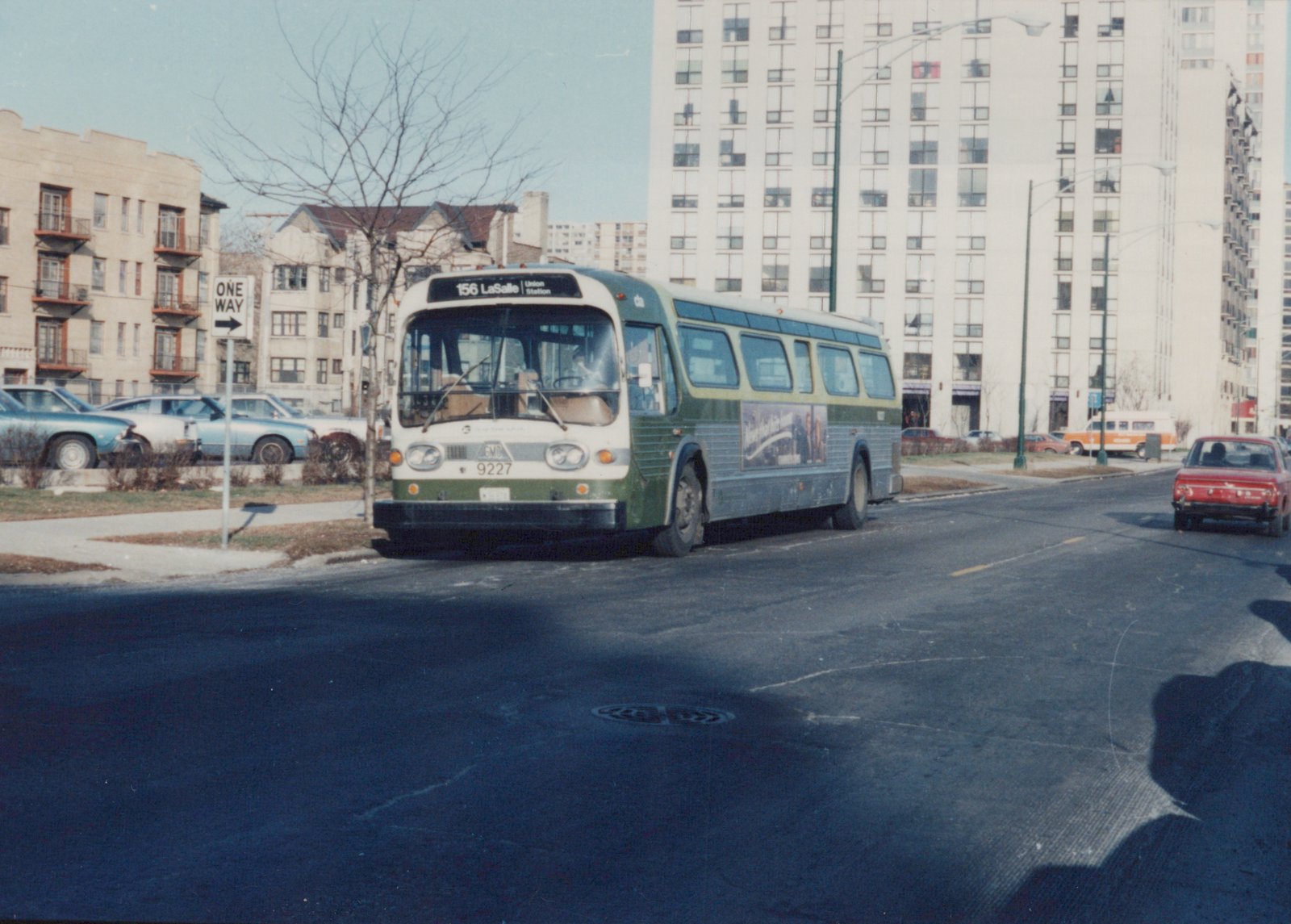 A green and cream Chicago Transit Authority bus, number 9227, on a winter street with other cars and apartment buildings in the background.