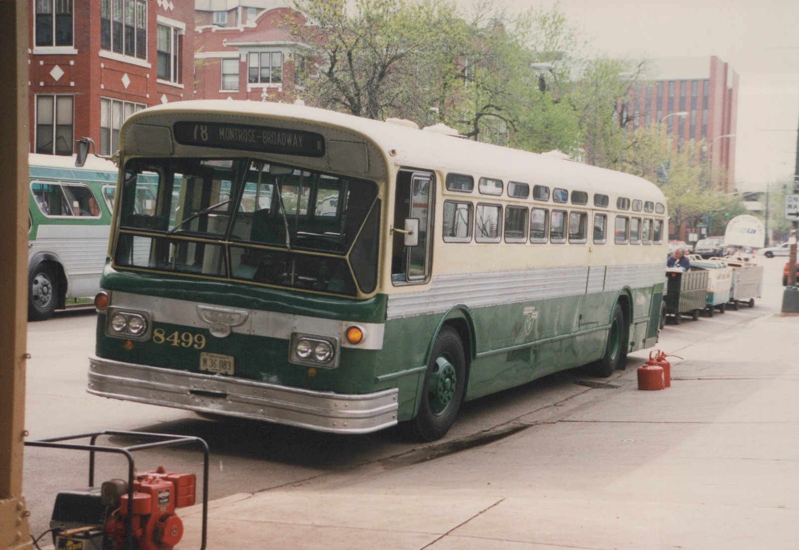 A green and cream Chicago Transit Authority bus, number 8499, is parked on a city street with its destination sign reading '78 Montrose-Broadway'.