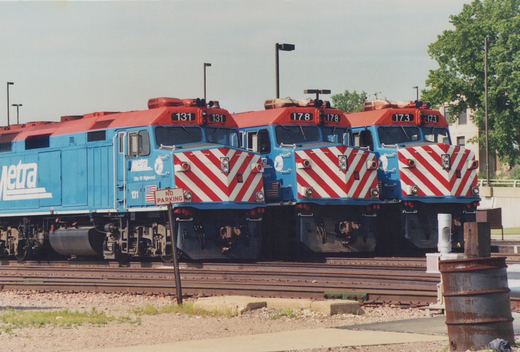 Three blue, red, and white Metra diesel locomotives numbered 131, 178, and 173 are parked on parallel tracks in a yard.