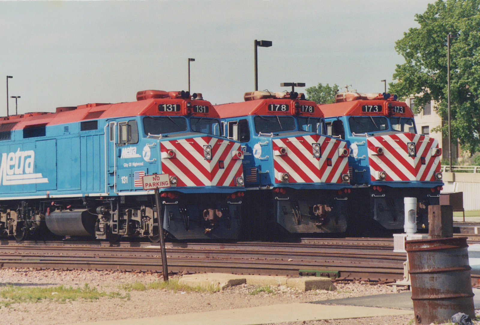 Three blue, red, and white Metra diesel locomotives numbered 131, 178, and 173 are parked on parallel tracks in a yard.