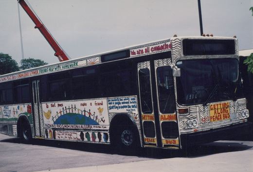 A white Chicago Transit Authority bus with colorful peace-themed artwork is parked on a city street on a sunny day; the bus number 4217 is visible.