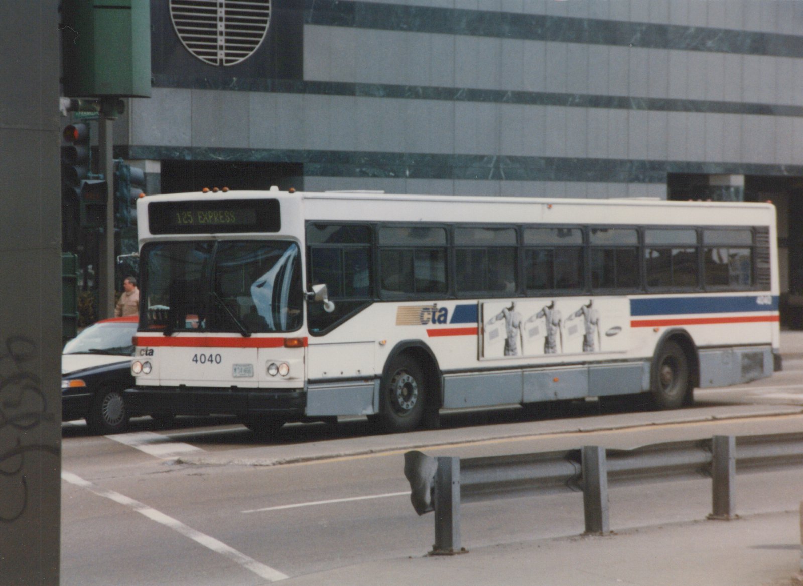 A white CTA bus with red and blue stripes, fleet number 4040, is driving on a city street; the destination sign reads '125 EXPRESS' and the location is Wacker and Franklin.