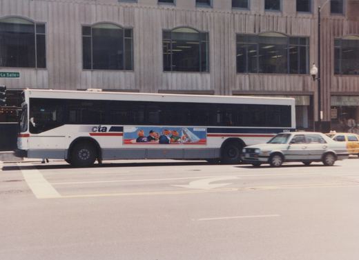 Side view of a white CTA motor bus, number 4064, stopped on a city street with a building and passing cars in the background.
