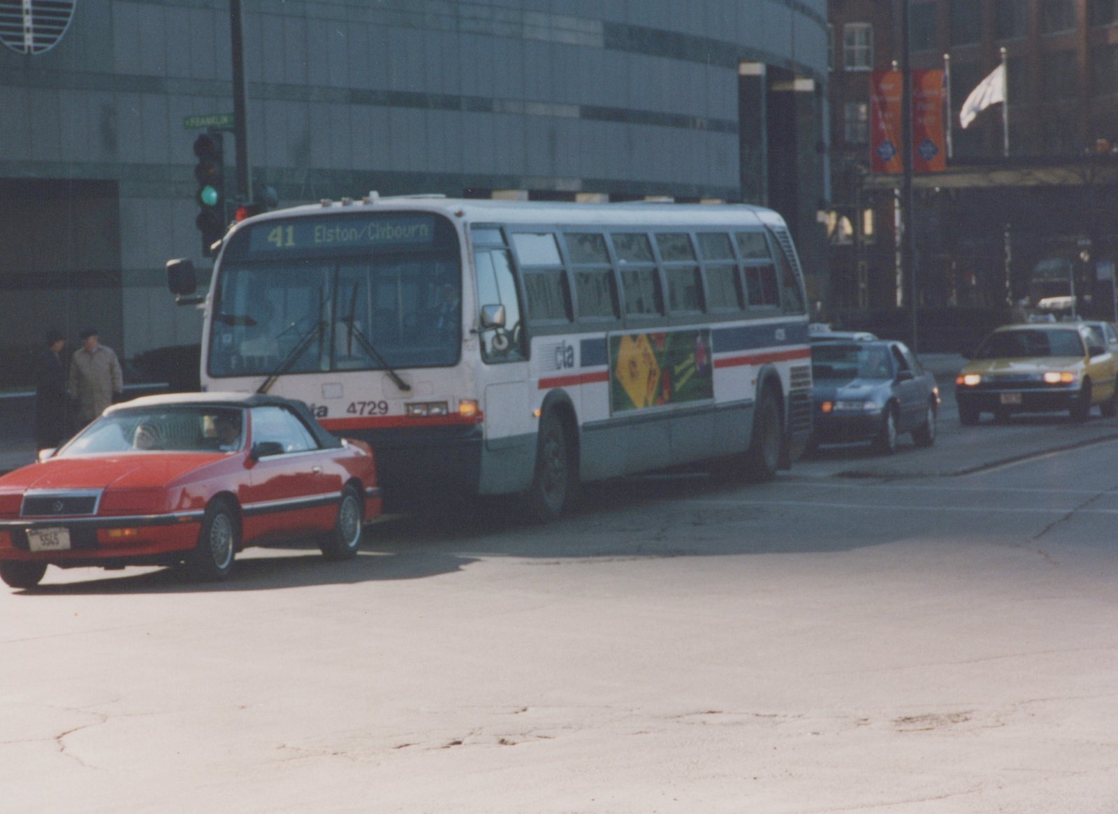 A white and blue Chicago Transit Authority bus, number 4729, on a city street with a red convertible and other cars, under a clear spring sky.