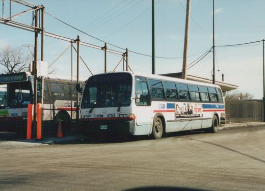 A white Chicago Transit Authority bus with the number 4753 on the front, featuring 'The Sopranos' advertisement on its side, parked on a street next to another CTA bus, number 5528, with bare trees and utility poles in the background.