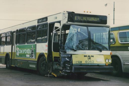 A white, yellow and green Chicago Transit Authority bus, number 4062, has a shattered windshield and crushed front bumper in a parking lot, with the destination sign reading K.41.4531.20521C.