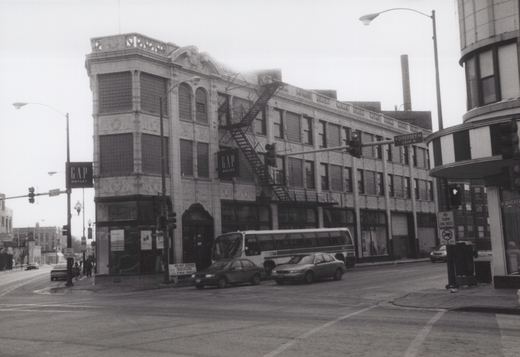 A black and white photo of a Chicago Transit Authority bus stopped at an intersection with a GAP Outlet store and street signs for Diversey Avenue visible.