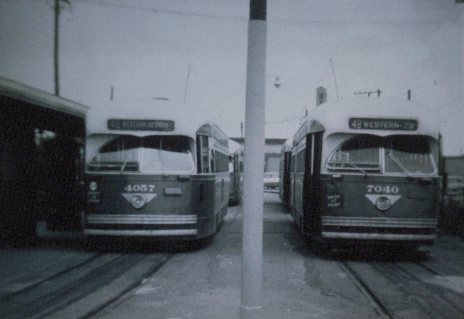 Front view of two Chicago Transit Authority PCC streetcars, numbers 4057 and 7040, parked side by side on streetcar tracks with destination signs visible, under overcast skies.