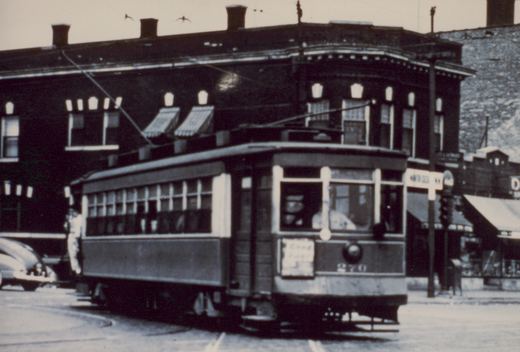 A vintage black-and-white photo of a Chicago streetcar, number 270, on a street with a building and a car in the background.