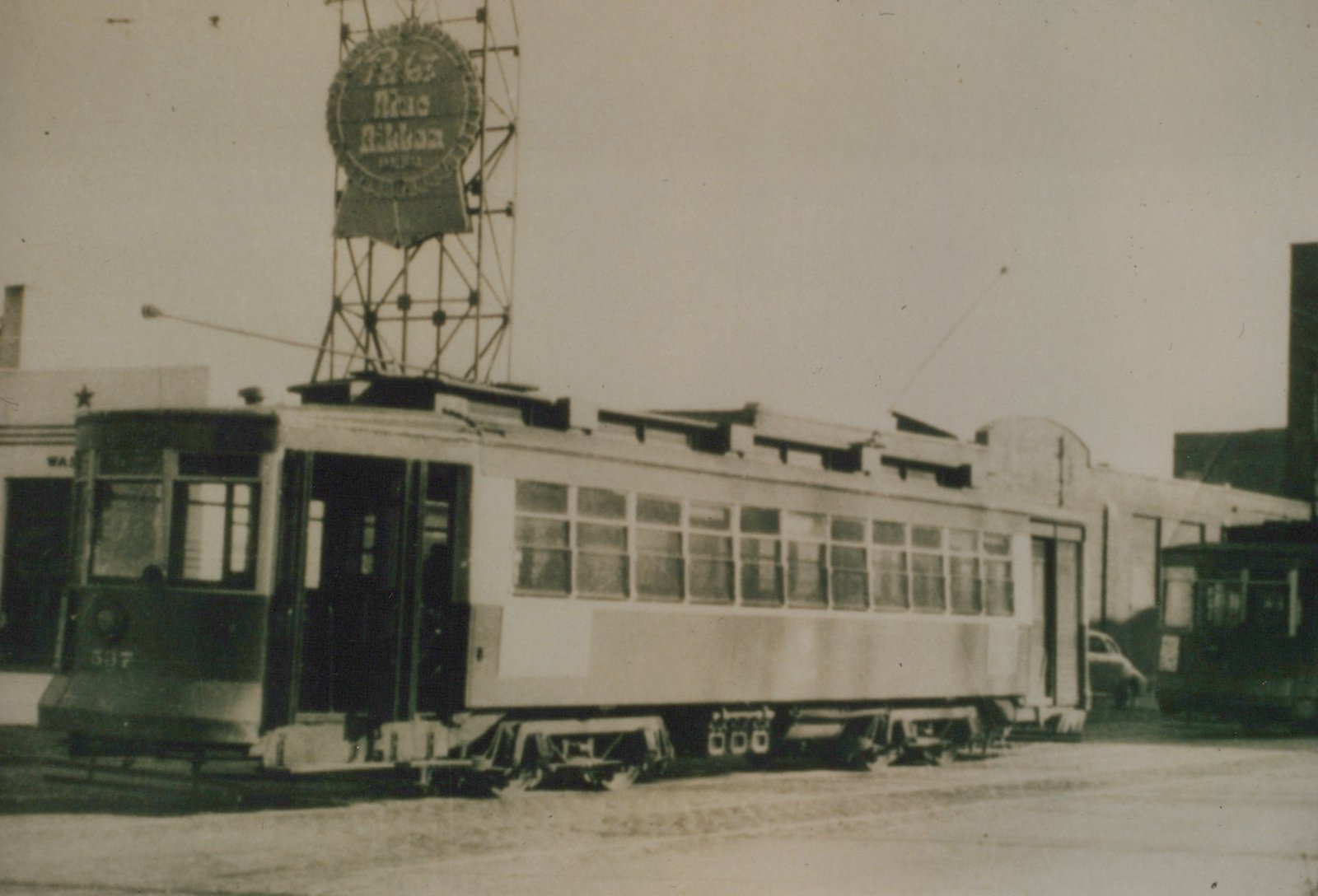 A vintage black-and-white photo of a Chicago streetcar numbered 507 parked on a snowy street, with a large circular billboard above it advertising Blue Ribbon Beer.