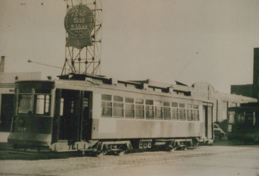 A vintage black-and-white photo of a Chicago streetcar numbered 507 parked on a snowy street, with a large circular billboard above it advertising Blue Ribbon Beer.