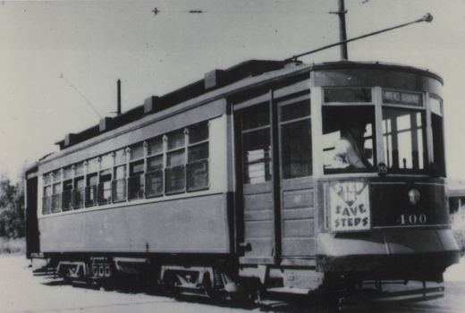A vintage black and white photograph of a Master Unit streetcar with fleet number 400, displaying a destination sign for LAWRENCE - BROADWAY and a 'STEP IN SAVE STEPS' sign on its front, parked on a snowy street.