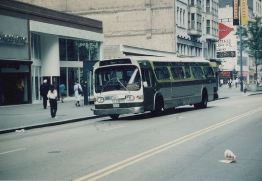 A green, black and white CTA bus numbered 1226 is stopped on a city street with pedestrians on the sidewalk and storefronts including 'Chess King' in the background.