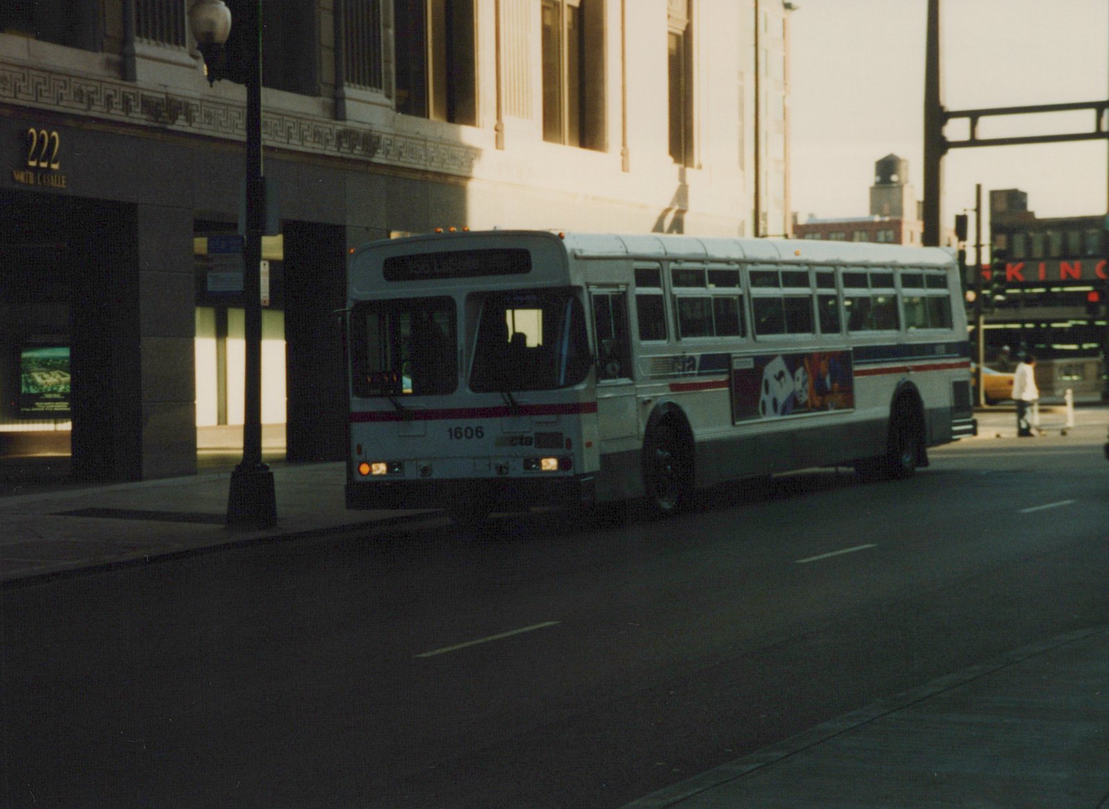 A white CTA bus with the number 1606 is parked on a city street next to a building marked 222 North La Salle.