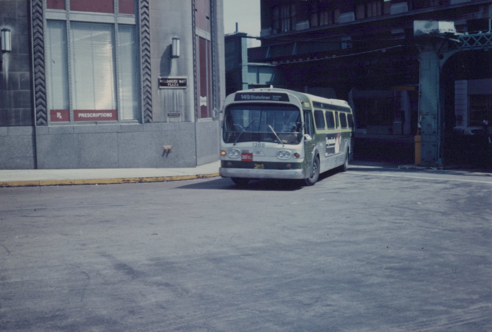 A green and white CTA bus numbered 1368, on route 149 Stateliner, is parked on a city street next to a building labeled Merchandise Mart Plaza.