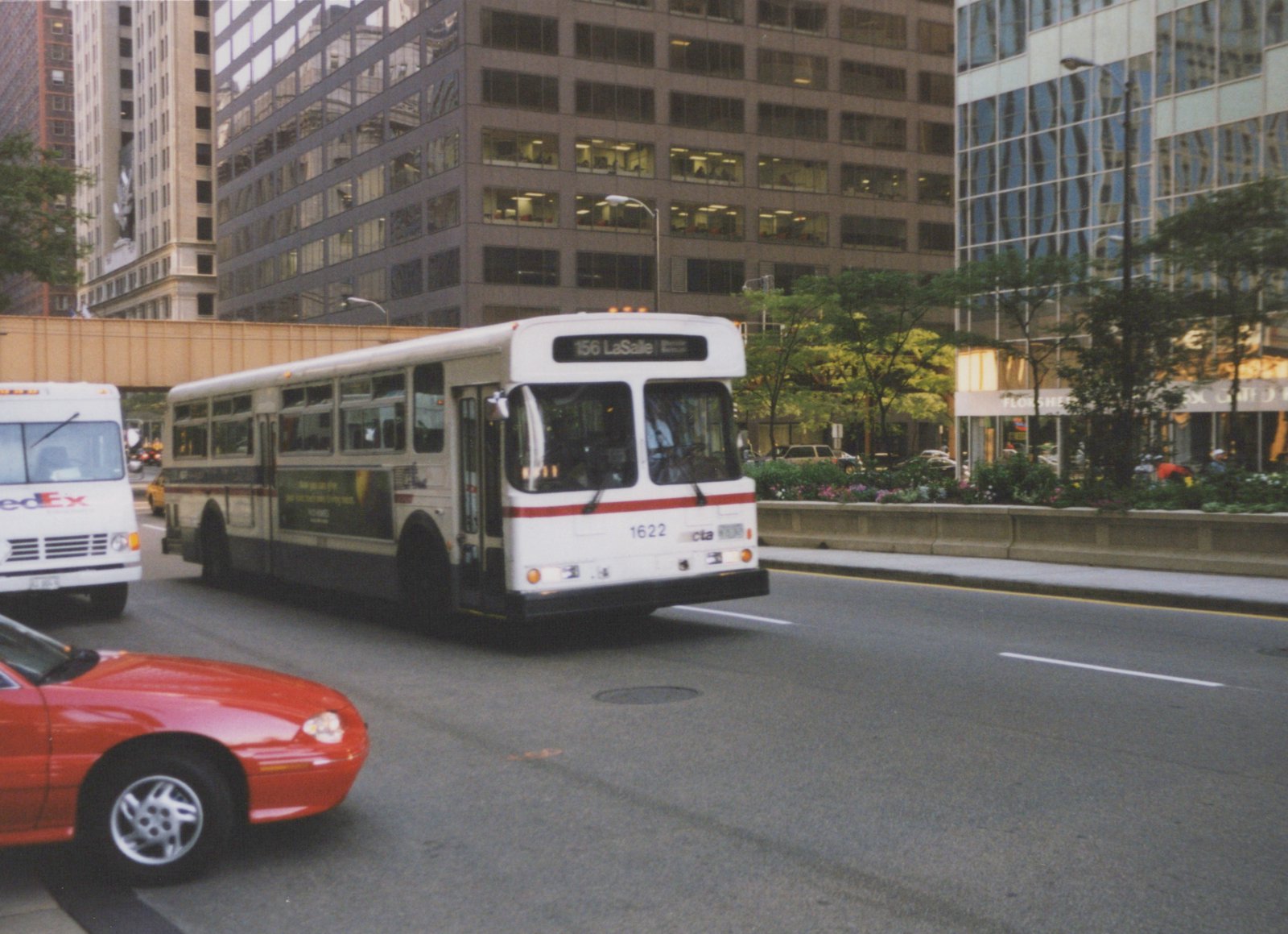 A white and red CTA bus numbered 1622 on the 156 LaSalle route drives on a city street, with tall buildings and other vehicles around it.