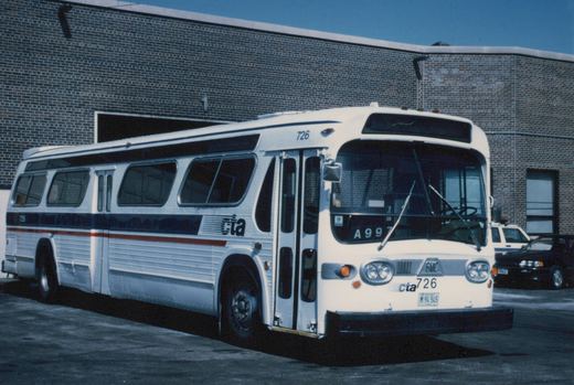 A white Chicago Transit Authority bus numbered 726, with blue and red stripes, is parked in front of a brick building; it is a GMC New Look model with the license plate M 94 545.