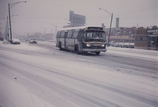 A green and white bus with the number 315 and route 95 Central-Diversey sign drives down a snow-covered street with cars and storefronts in the background.