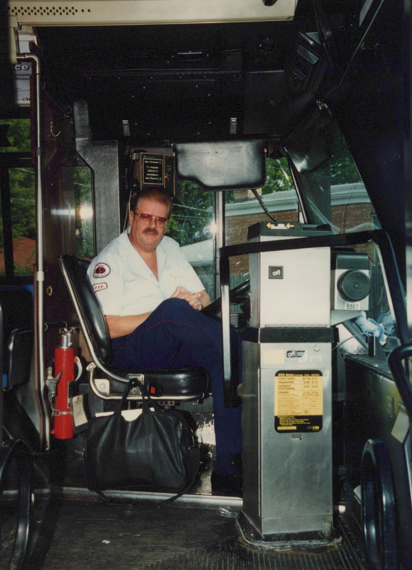 Interior view of a bus showing the driver in uniform, seated at the wheel, with a farebox displaying the number 5367 and operator CTA.