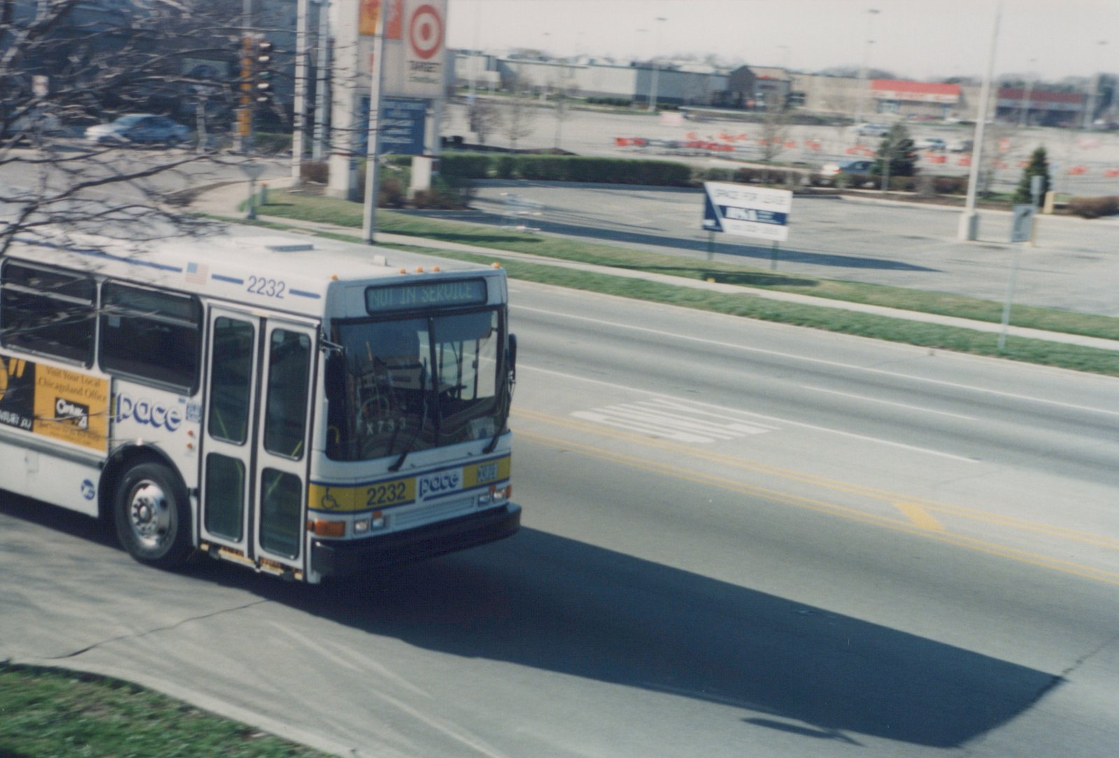 A white Pace bus with the number 2232 and 'NOT IN SERVICE' on the front sign drives down a street with a Target store in the background.
