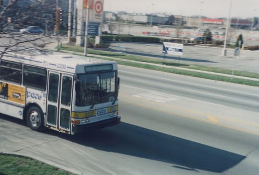 A white Pace bus with the number 2232 and 'NOT IN SERVICE' on the front sign drives down a street with a Target store in the background.