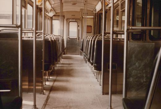 The interior of a Budd-built electric multiple-unit car, with rows of seats, grab rails, and the car number 2302 visible above the far door.