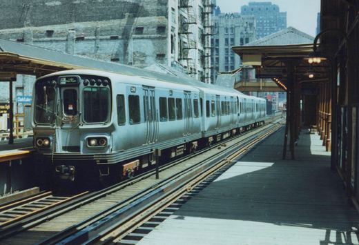 A silver CTA train with the number 249 and destination 'Lake Dan Ryan' is stopped at an elevated station platform with the sign 'Clark/Lake' visible.
