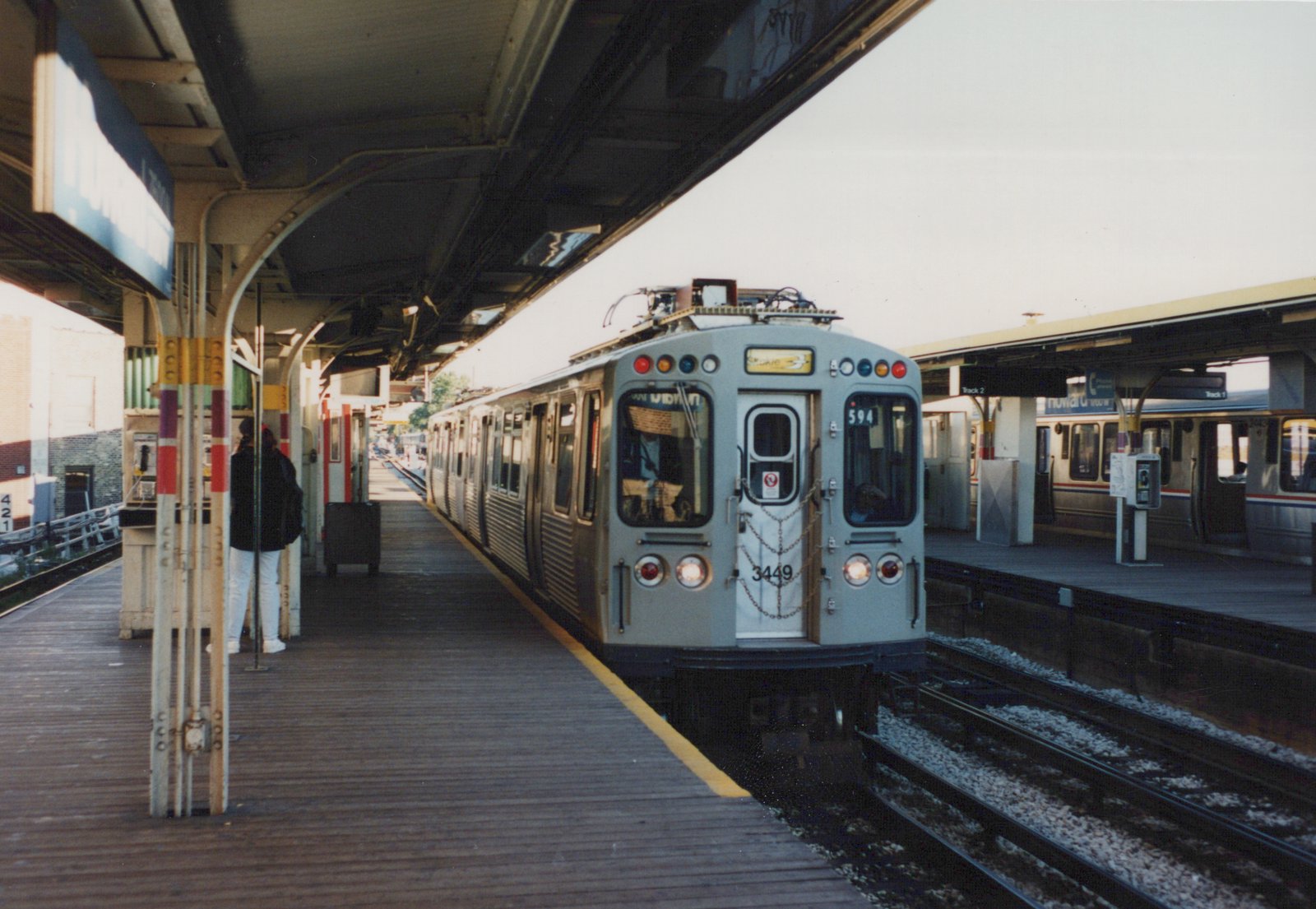 A gray CTA rapid transit car, number 3449, is stopped at the Howard Terminal platform with another car visible on the adjacent track.