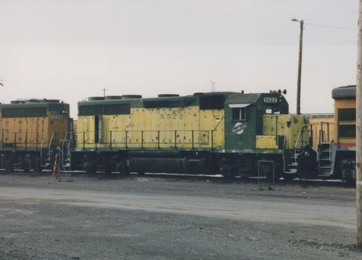 Side view of two Chicago and North Western diesel locomotives, numbers 5522 and 5508, parked in a gravel yard under an overcast sky in May 1999.