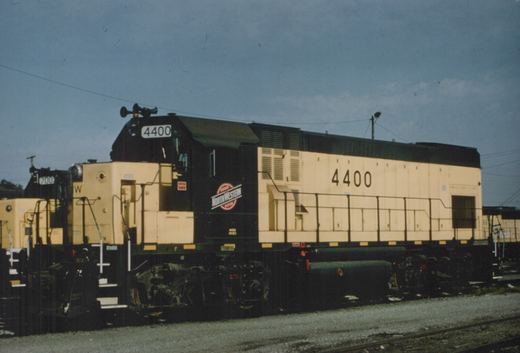 A side view of a Chicago and North Western GP15-1 diesel locomotive, number 4400, standing on tracks in a rail yard under an overcast sky.
