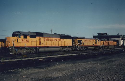Three Union Pacific diesel locomotives, numbered 5036, 105, and 5003, side by side in a yard under a clear sky.