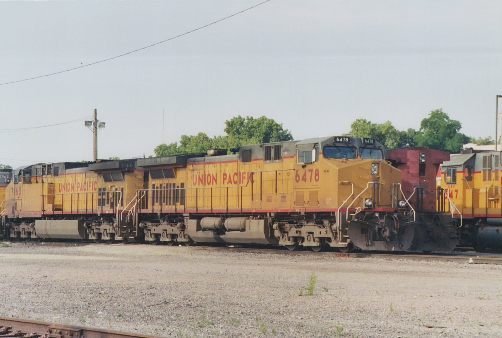 Union Pacific locomotives 6478 and 7165, both EMD SD40-2s, are parked side by side in a yard, with another locomotive visible behind them.