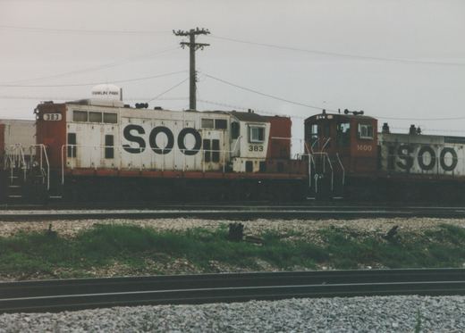 Two white and red SOO Line diesel locomotives, numbered 383 and 1400, are parked on parallel tracks in Franklin Park, Illinois, with a water tower visible in the background.