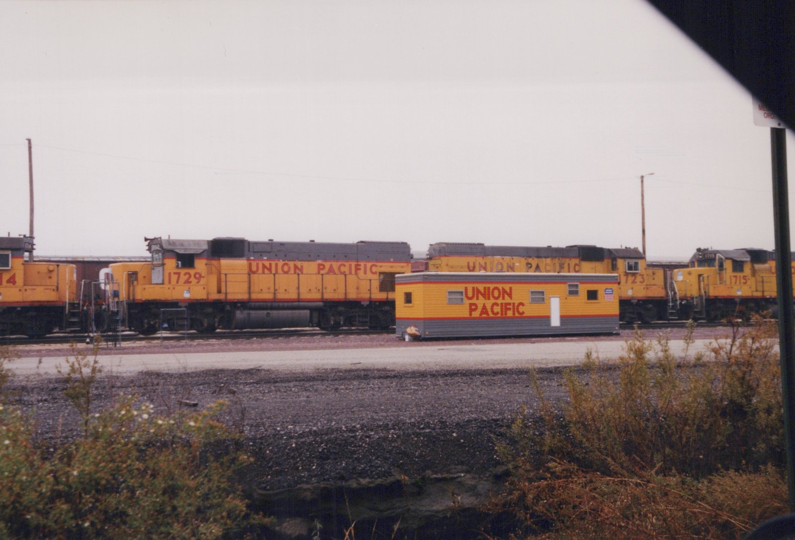 Four Union Pacific diesel locomotives numbered 1729, 1723, 1715, and 14 are parked side by side in a rail yard, with a yellow and gray Union Pacific work car in front.
