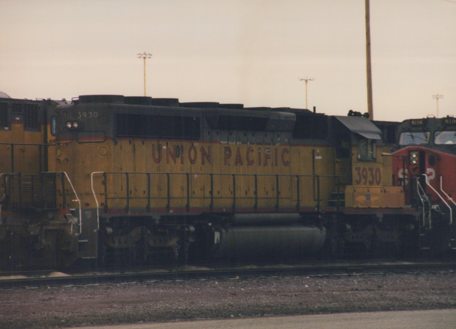 A Union Pacific diesel locomotive numbered 3930 is parked in a yard, with another locomotive behind it.