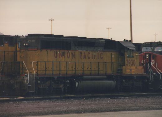 A Union Pacific diesel locomotive numbered 3930 is parked in a yard, with another locomotive behind it.