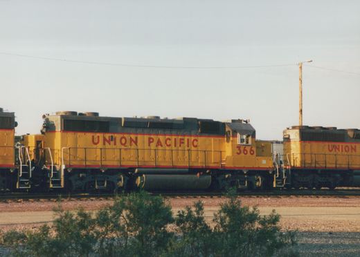 Three yellow Union Pacific diesel locomotives are parked on tracks in a yard under a clear sky, with the lead unit numbered 366.