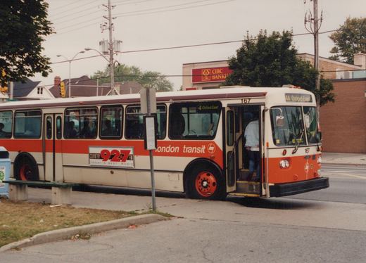 A cream and orange bus with 'London Transit' lettering, fleet number 167, displays the destination '4A Oxford East' and is stopped at a street-side bus stop in a suburban setting.