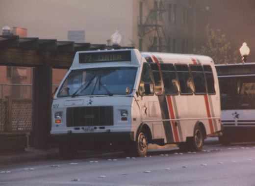 A white Fort Worth transit bus with red and grey stripes and a star emblem, displaying route 72 Central, parked on a city street at dusk.