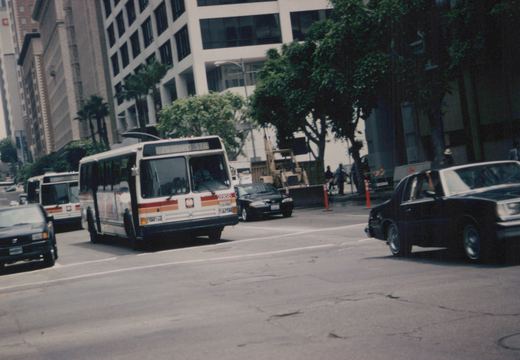 A white and orange Chicago Transit Authority bus with the number 2868 and destination '78 Grand Sta' is driving on a city street alongside cars and another bus.