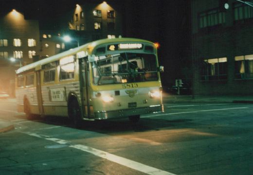 A yellow and white CTA bus numbered 5813 drives down a city street at night, its headlights on and its destination sign reading 42 South-Central Exp.