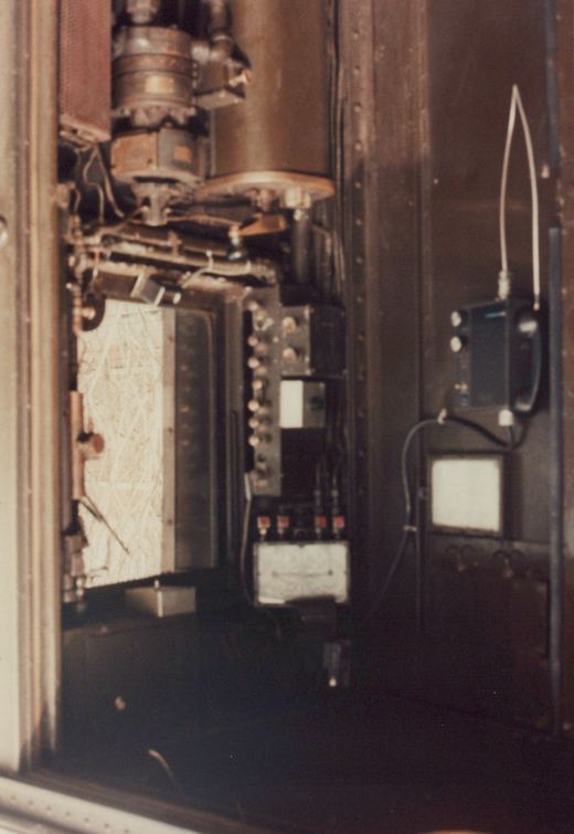 An interior view showing a panel of dials, wires, and a mounted radio unit inside a vehicle.